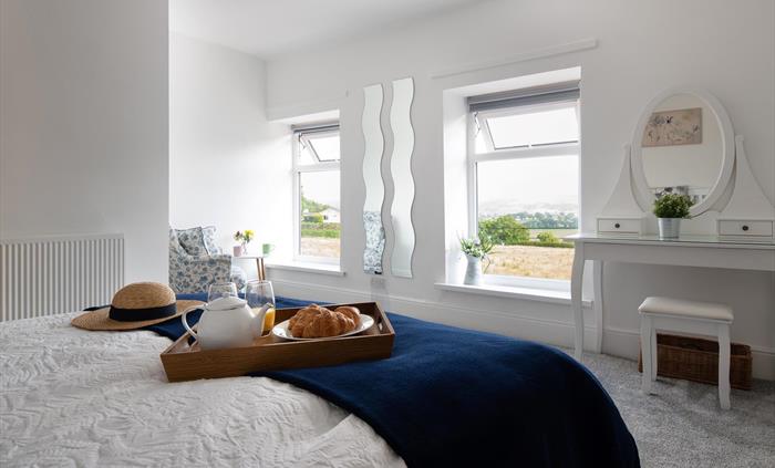 This large and bright room also has a comfortable armchair.  Ideal for sitting with a drink and a book while you take in the view